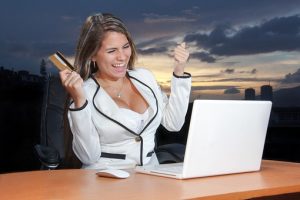 blond girl looks happy in front of a laptop